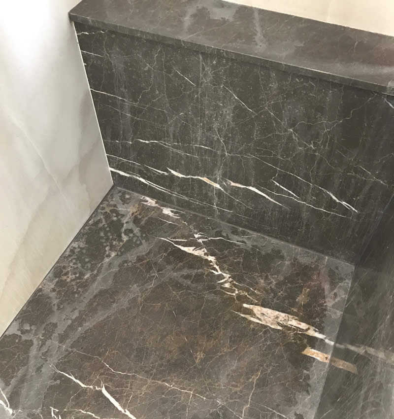 Marble tiles in a bathroom with accrued heavy water damage